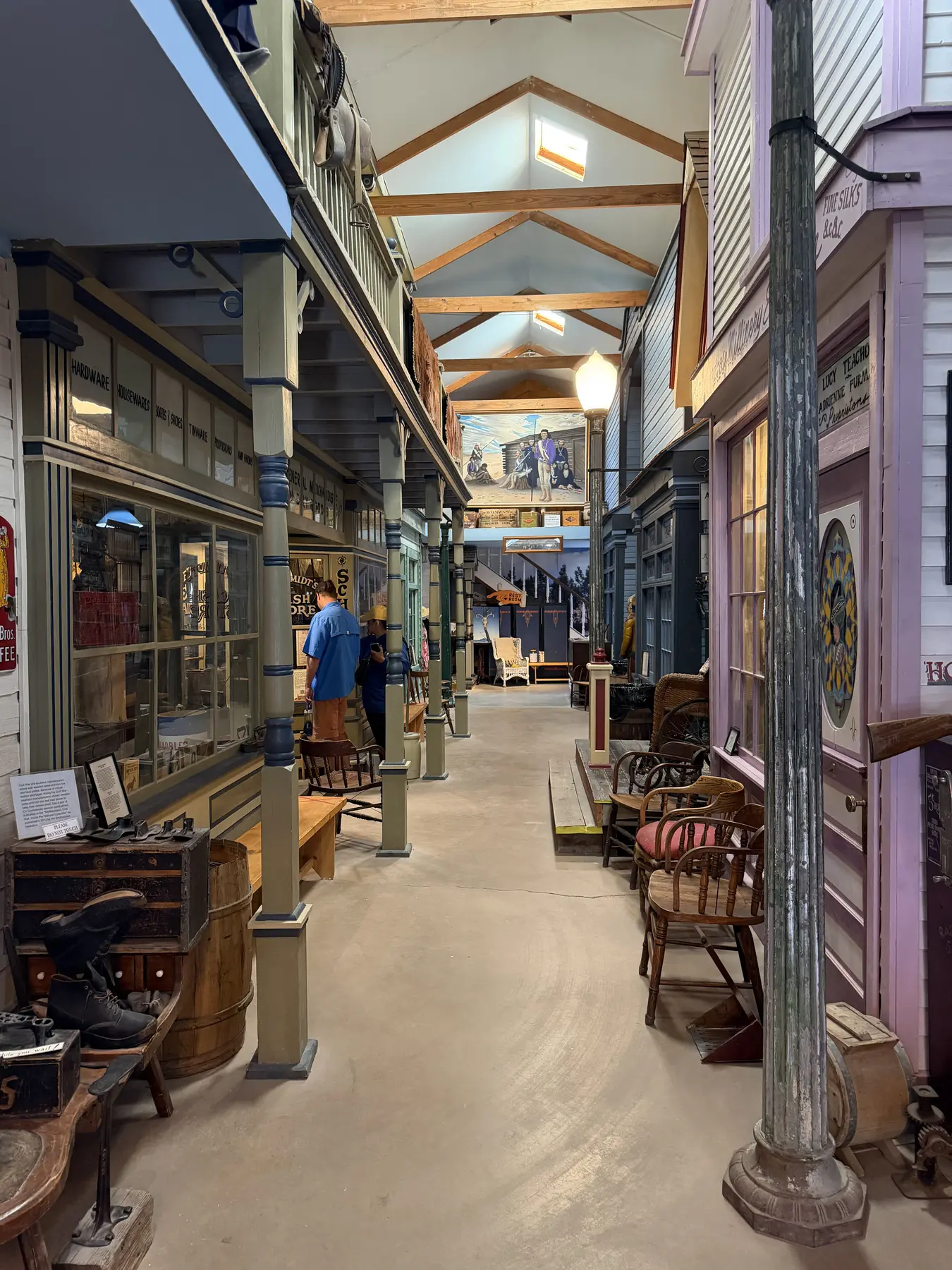 A long indoor museum walkway lined with reconstructed historic storefronts and artifacts
